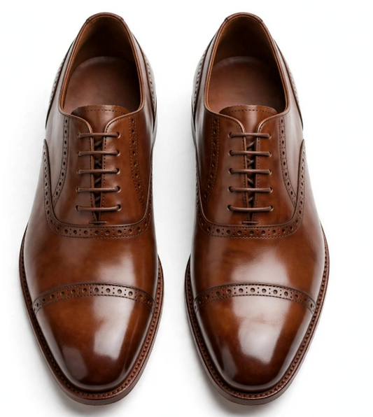Tan brown Oxford brogue dress shoes top-down view on white background